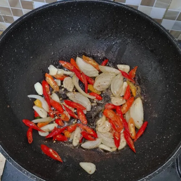 Gunakan wajan bekas goreng ikan pindang, lalu tumis bumbu iris. Masak hingga bumbu harum dan layu, lalu tambahkan sedikit air.