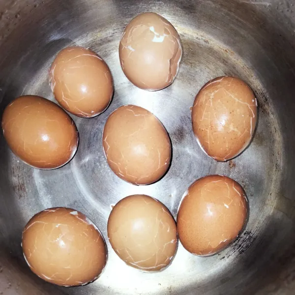 Angkat lalu retakan telur dengan cara dibenturkan ke meja.