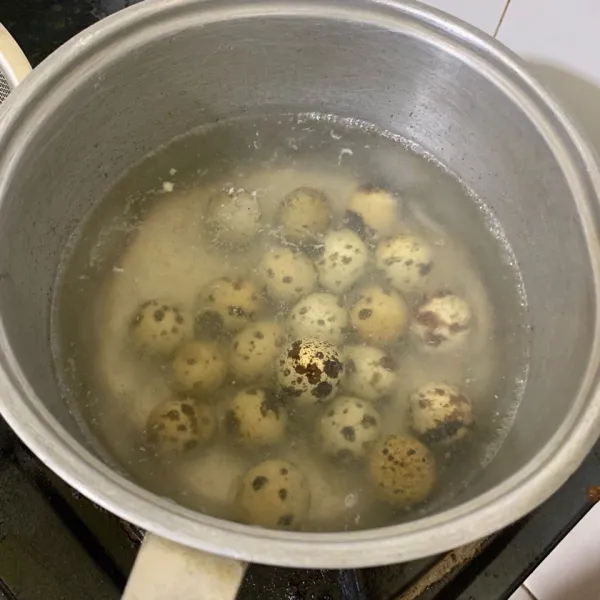 Rebus telur puyuh dalam air mendidih selama 5 menit. Angkat dan kupas kulitnya.