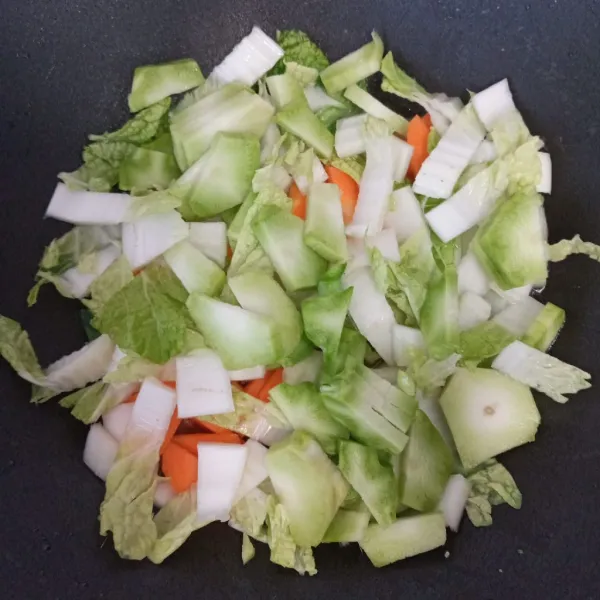 Masukkan wortel, batang sawi putih, batang brokoli, dan air. Aduk rata dan masak hingga wortel setengah matang.