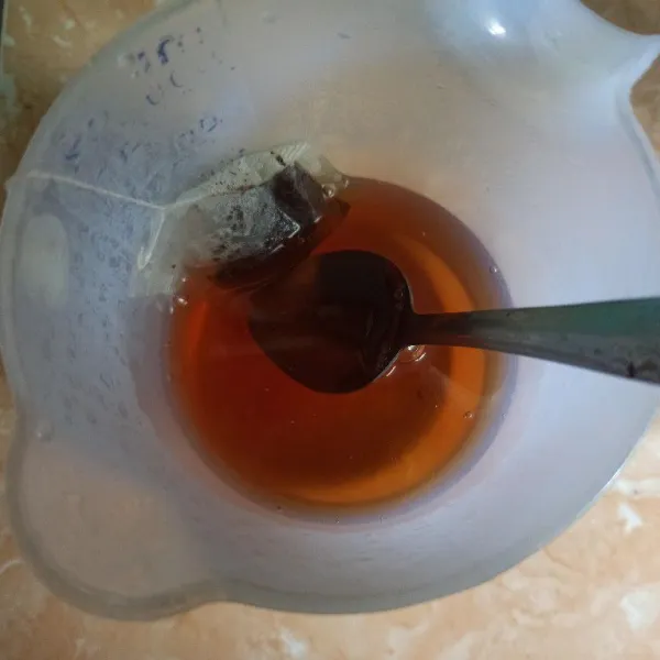 Seduh teh dengan air panas lalu tambahkan gula pasir aduk rata, dan koreksi rasanya terlebih dahulu.