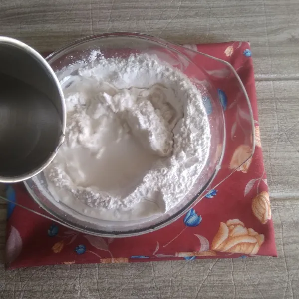 Dalam mangkuk, campur kedua tepung, lalu tuangi air hangat sedikit demi sedikit sambil diuleni hingga kalis.