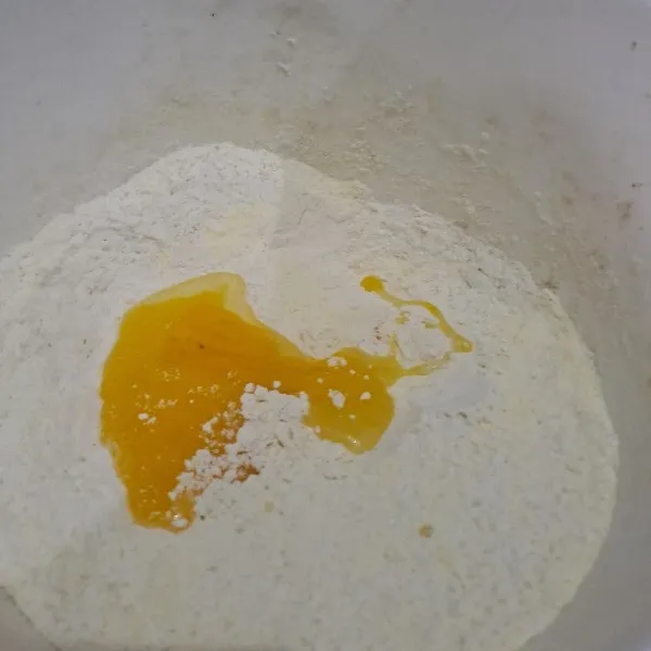 Campur tepung terigu, gula pasir, susu bubuk dan ragi instan, aduk rata lalu masukan kuning telor, aduk rata.