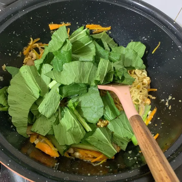 Tambahkan potongan sawi. Aduk rata kembali. Pindahkan ke piring saji, tambahkan potongan daun bawang, wijen dan bawang goreng di atasnya. Mie panjang umur siap disajikan.