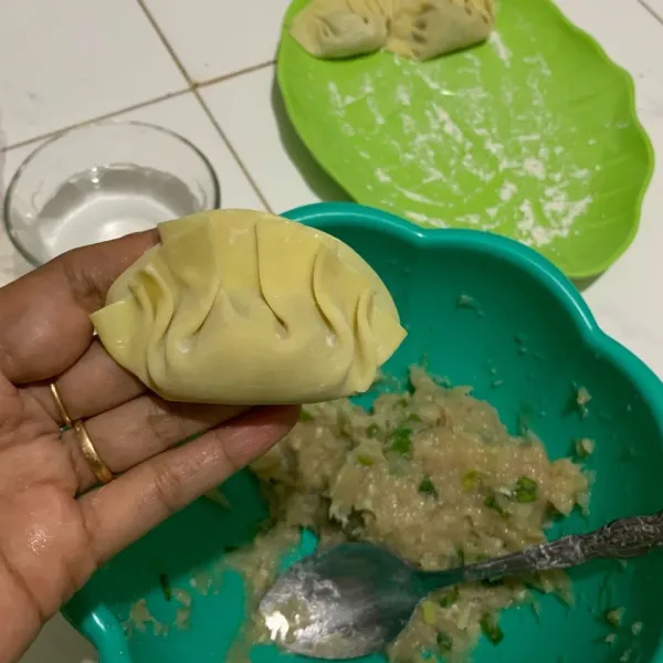 Lalu lipat menjadi dua dan diberikan lipatan kecil-kecil di atasnya seperti dumpling.