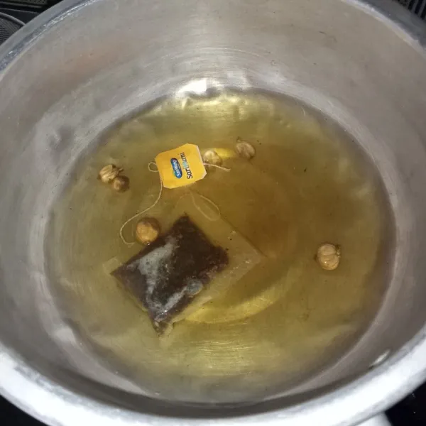 Matikan kompor dan masukkan teh, biarkan air teh sampai berubah warna.
