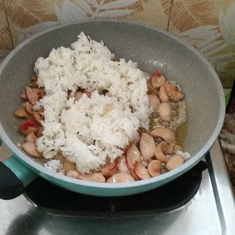 Masukkan nasi putih, aduk sebentar.