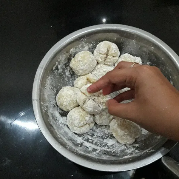 Taburi bakso kentang dengan secukupnya tepung tapioka. Belah bagian tengah menjadi 4 bagian jangan sampai putus. Taburi juga bagian tangan dengan tepung tapioka biar tidak lengket.