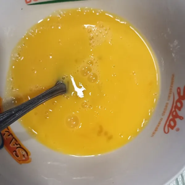 Kocok lepas telur dalam wadah dan beri 1/4 sendok teh bumbu halus