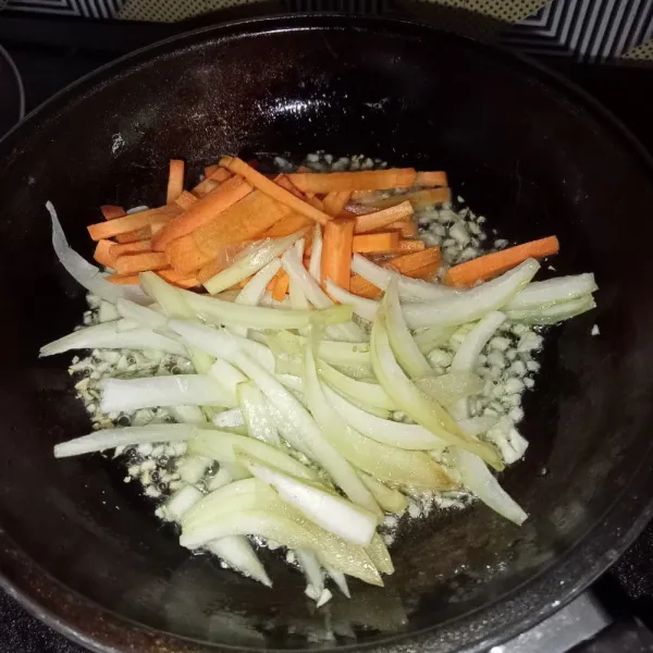 Masukkan wortel dan bawang bombay, aduk-aduk dan tumis sampai sedikit layu.