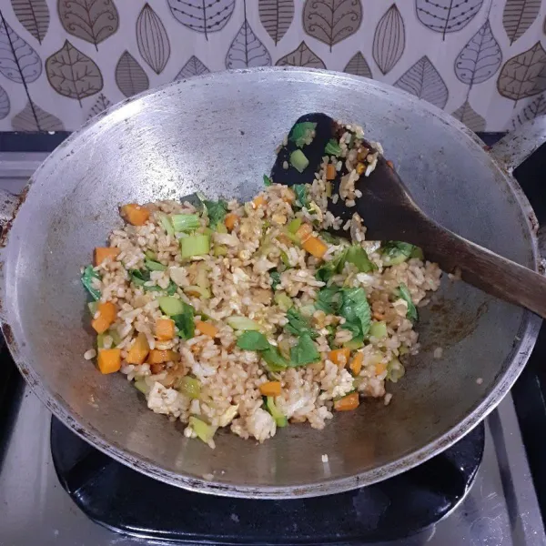 Aduk rata, masak hingga daun layu. Nasi goreng sayur siap dihidangkan.