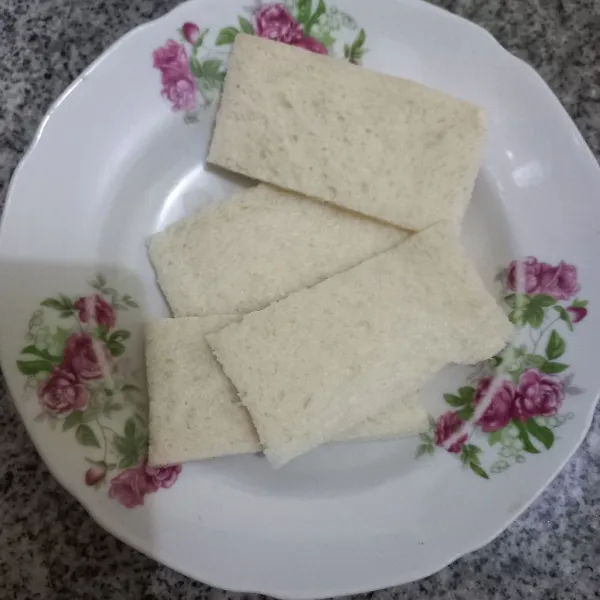 Siapkan lembaran roti tawar, potong menjadi 2 bagian.