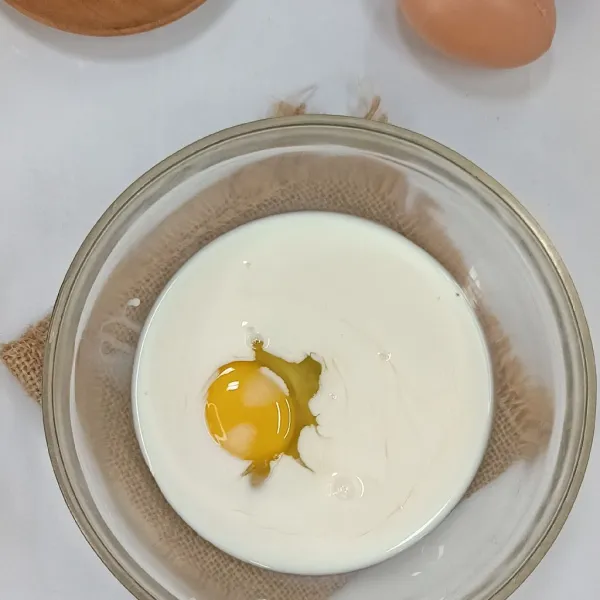 Kocok susu dan telur dalam wadah.