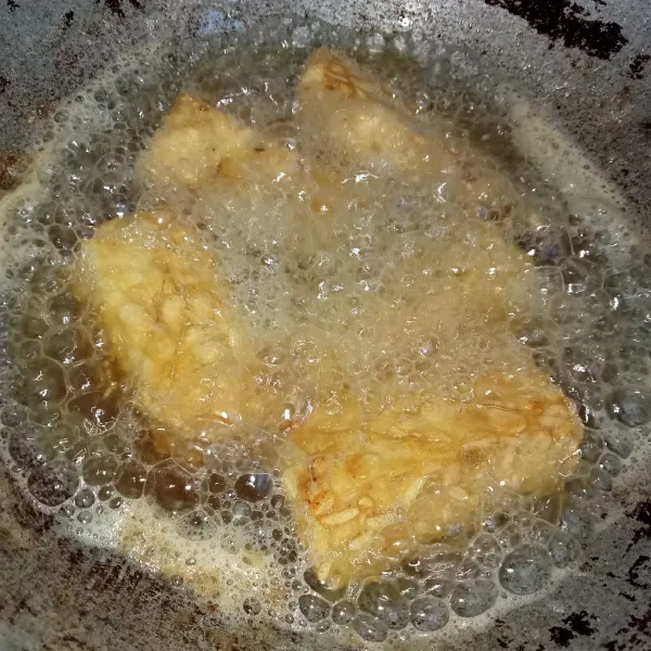 Panaskan minyak lalu masukkan tempe, goreng tempe hingga kuning keemasan, angkat dan tiriskan. Sajikan.