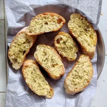 Oles roti dengan campuran mentega. Dan tambahkan topping keju parmesan dan parsley kering.