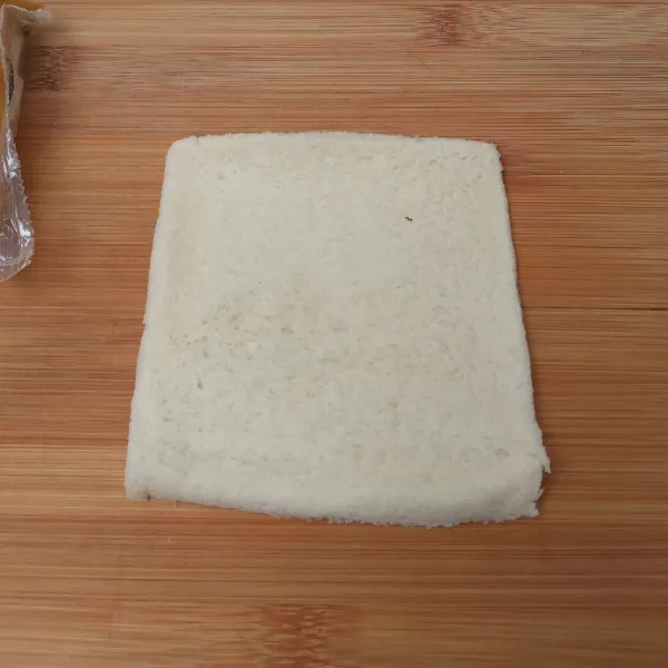 Pipihkan roti dengan bantuan rolling pin.