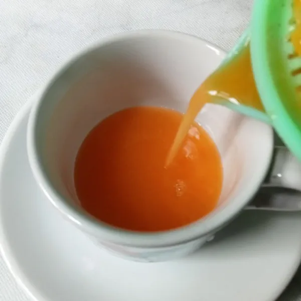 Tuang air jeruk ke dalam gelas atau cangkir.