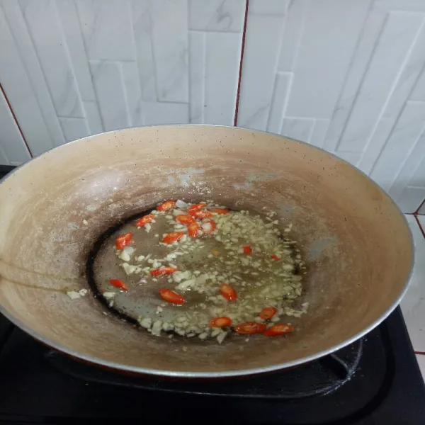 Panaskan minyak lalu tumis bawang merah, bawang putih dan cabe hingga harum.