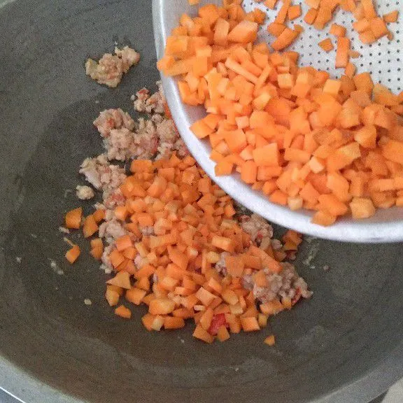 Tumis bumbu halus dan ayam cincang hingga aromanya harum. Masukkan wortel dan air lalu masak hingga wortel empuk.