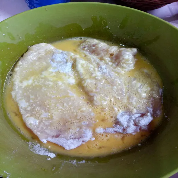 Lalu celupkan ayam ke dalam adonan telur kocok dan balur kembali ke adonan tepung hingga terbalur kedua sisinya.