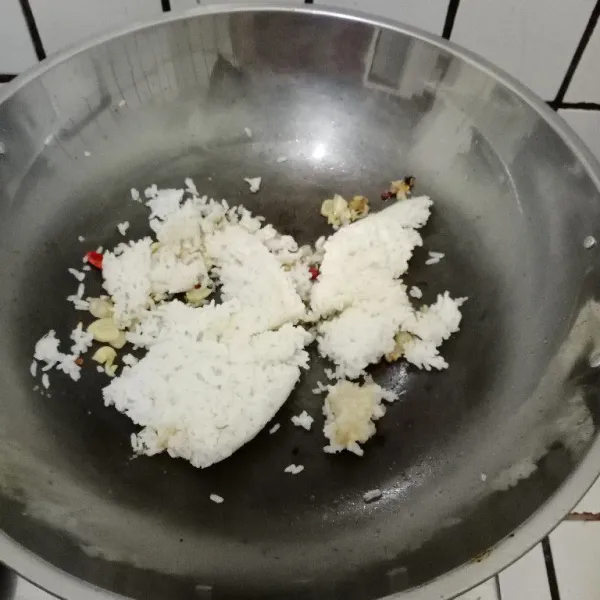 Masukkan nasi. Aduk rata. Tambahkan telur, aduk cepat