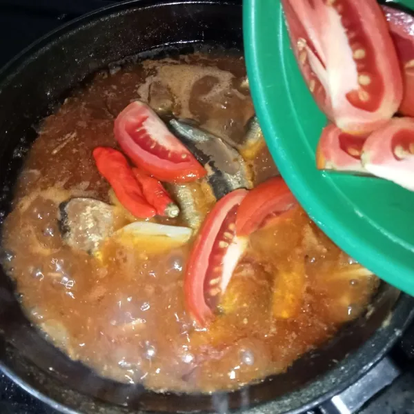 Masukkan irisan tomat dan cabai rawit utuh.