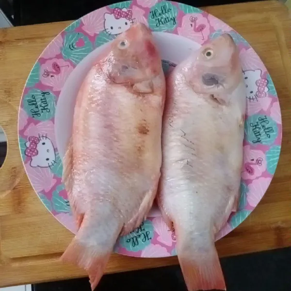 Siapkan ikan nila segar. Bersihkan sisik dan isangnya.