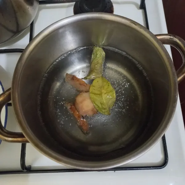 Didihkan air dalam panci bersama lengkuas dan daun salam.