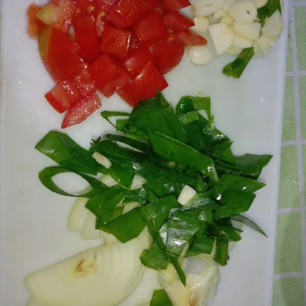 Potong dadu tomat, iris tipis daun bawang, bawang putih dan bawang bombai.