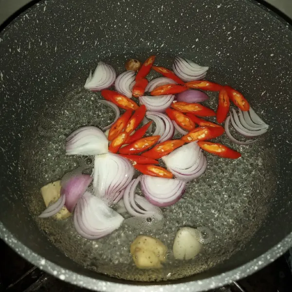 Didihkan air dengan api sedang lalu masukkan bawang putih, jahe, bawang merah, biji pala dan cabe merah keriting selama 5 menit.