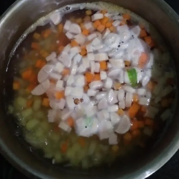 Panaskan air hingga mendidih, masukkan bawang putih cincang, lalu tambahkan wortel dan kentang. Masak hingga setengah matang, masukkan sosis dan jamur, masak kembali.