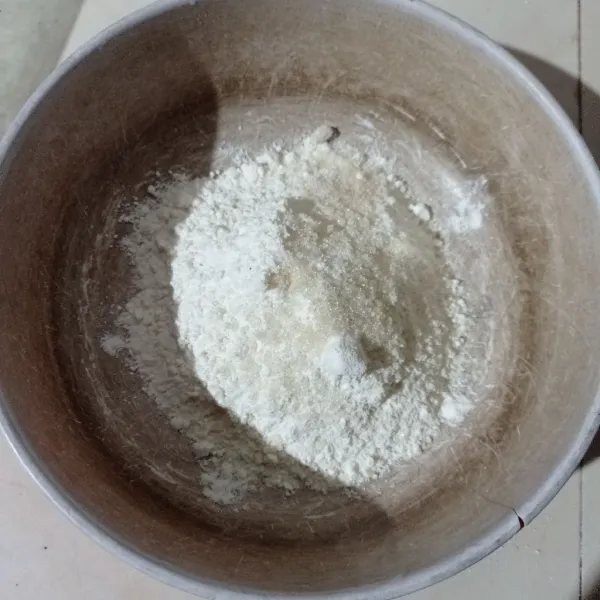 Masukkan tepung terigu, garam, dan gula pasir ke dalam wadah.