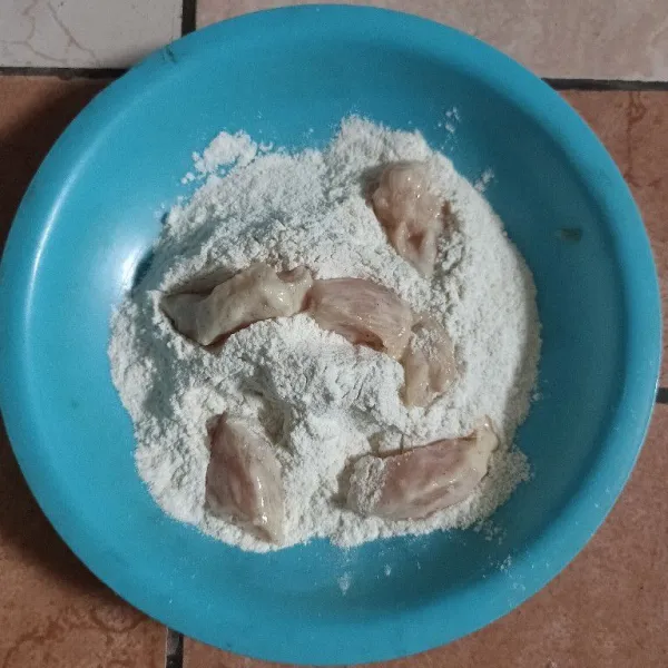 Balur ayam ke dalam tepung bumbu kering hingga tertutup semuanya.