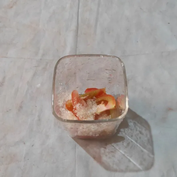Masukkan potongan tomat dan gula pasir dalam gelas saji.