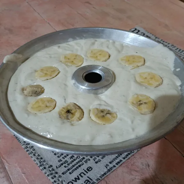 Tuang ke dalam loyang diameter 18 cm yang sudah dioles carlo atau margarin dan tepung. Hentakkan 3x dan beri topping pisang (opsional).