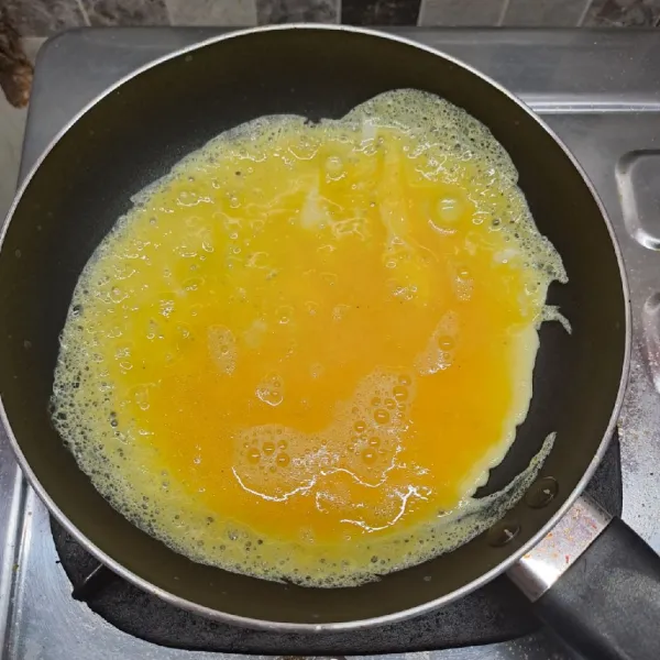 Panaskan teflon dengan sedikit margarin. Tuang adonan telur sampai rata.