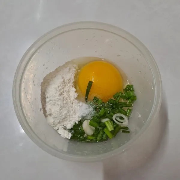 Dalam mangkok pecahkan telur, tambahkan tepung terigu, daun bawang dan garam. Aduk sampai tercampur rata.