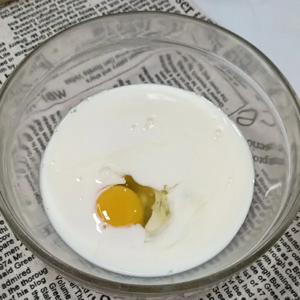 Kocok telur dan susu dalam wadah.