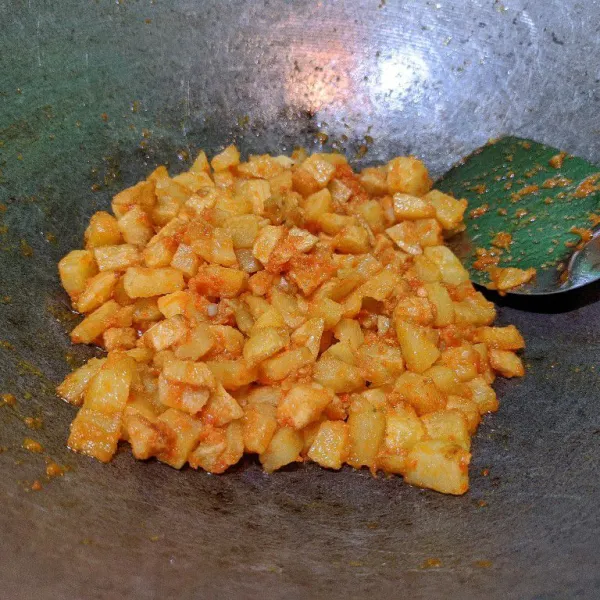 Masukkan kentang yang telah digoreng, tambahkan secukupnya garam, kaldu bubuk dan gula pasir. Aduk hingga merata. Kecilkan api, biarkan sejenak agar bumbu sambal meresap ke kentang. Test rasa.