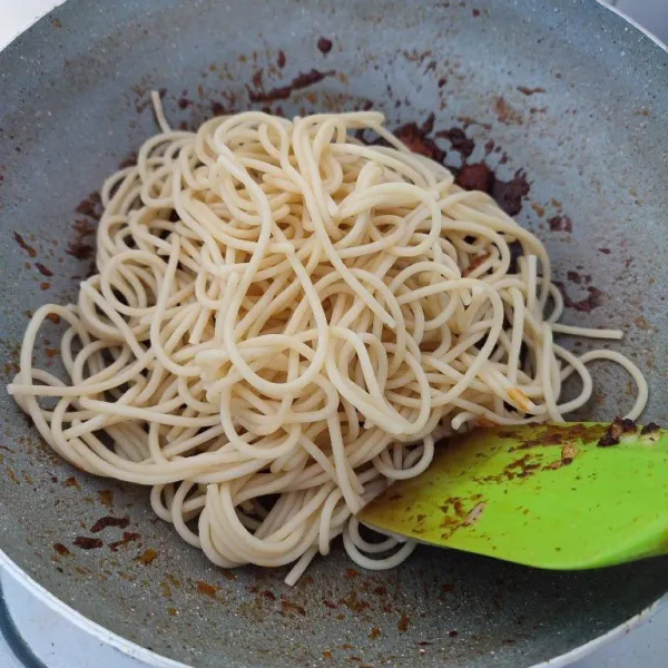 Setelah menyusut, masukkan spaghetti dan irisan daun bawang, aduk rata dengan bumbu rendang. Sajikan selagi hangat.