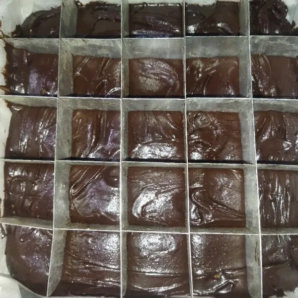 Siapkan loyang yang sudah dialasi baking paper, tuang semua adonan brownies, lalu pasang sekatnya.