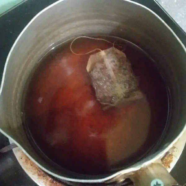 Masukkan kantong teh celup, biarkan terekstrak dan air suam kuku.
