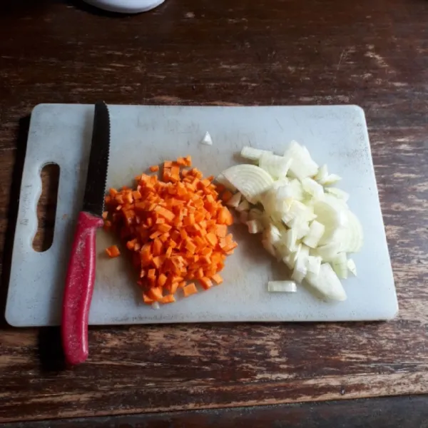 Cincang bawang putih, potong dadu bawang bombai dan wortel.