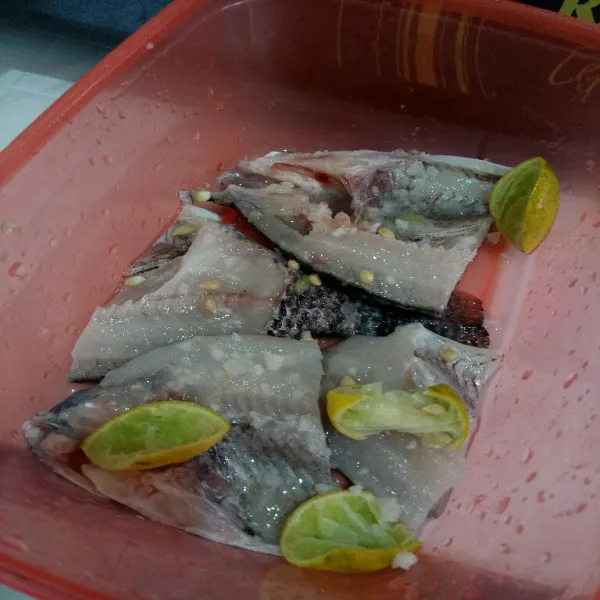 Cuci bersih ikan lalu beri perasan jeruk nipis dan garam kasar, diamkan selama 15 menit.