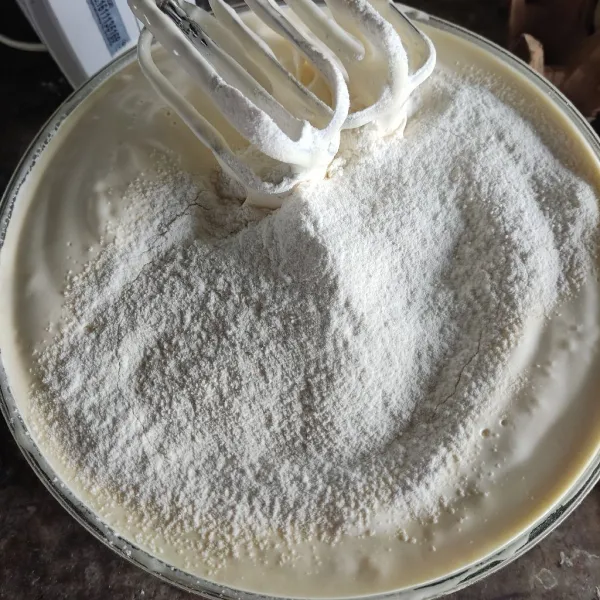 Ayak tepung dan vanili, masukkan secara bertahap.