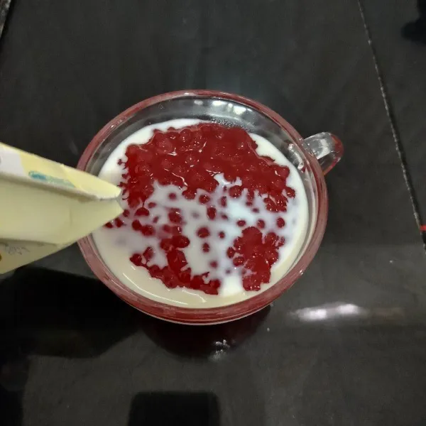 Tuang secukupnya bubur mutiara ke dalam cangkir atau mangkuk. Lalu tambahkan susu cair.