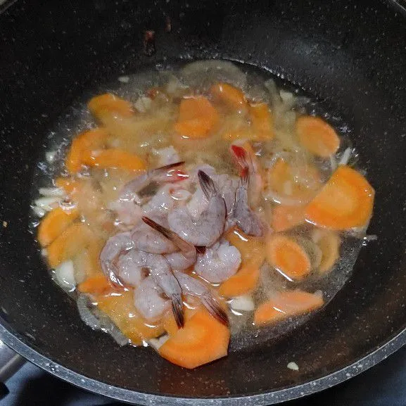 Setelah wortel matang, masukan udang kupas, masak hingga udang berubah warna.