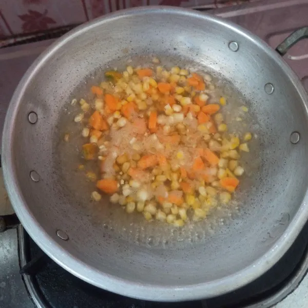Rebus air hingga mendidih, setelah mendidih masukkan jagung dan wortel, rebus selama 5-7 menit, selanjutnya angkat dan tiriskan.