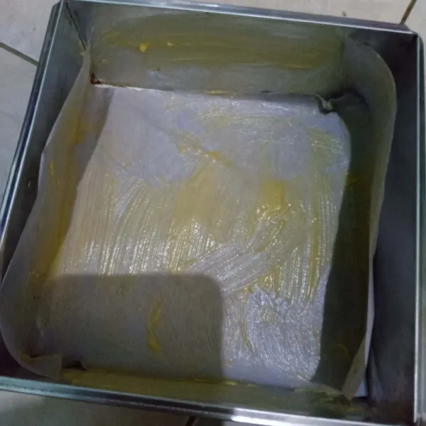 Oles loyang yang telah dialasi kertas roti dengan carlo atau margarin. Tuang adonan dalam loyang.