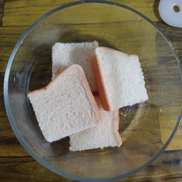 Ambil satu lembar roti tawar, potong-potong kemudian tata di dalam wadah yang sudah disediakan.